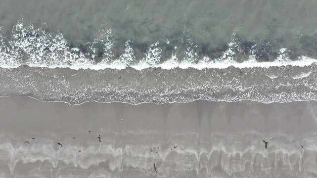Close Aerial View of Breaking Waves on Sandy Beach at Nagahama, Ishinomaki, Japan