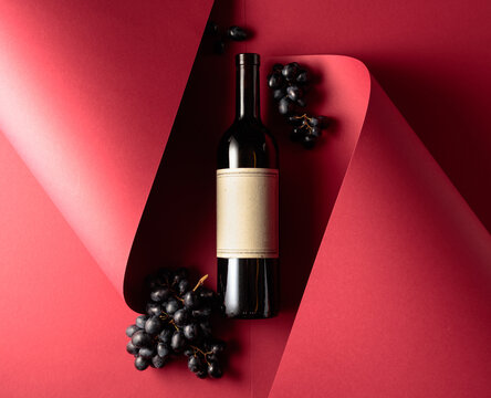 Bottle of red wine and blue grapes.