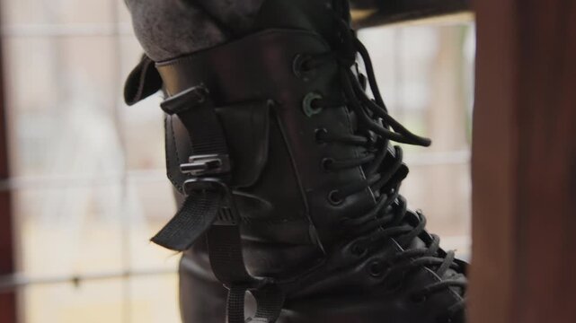 Focused boot closeup. Intimate shot of sturdy combat boot highlighting utility features. Precise capture of tactical footwear emphasizing functional design and metallic hardware details