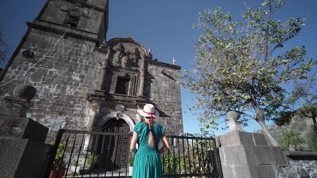 Senior woman visits San Javier Mission near Loreto. She smiles and enjoys the historic site during sunrise in Baja California Sur