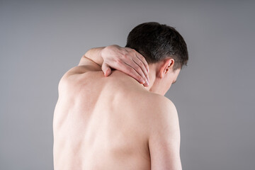 Naklejka premium Neck pain, cervical spine hernia, man suffering from ache on gray background