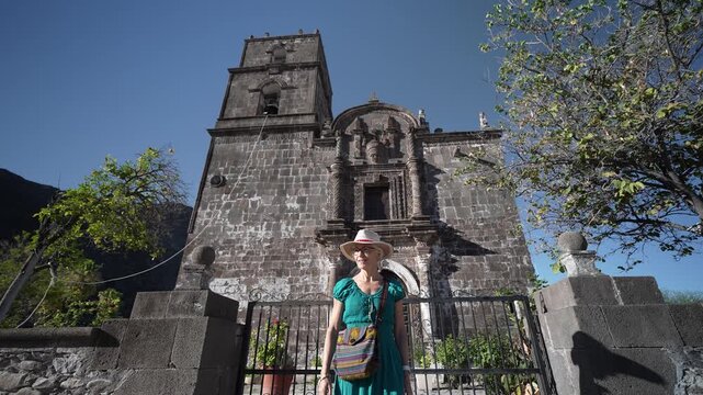 A senior woman enjoys her visit to San Javier Mission near Loreto, Baja California Sur at sunrise, happy to explore the historic site