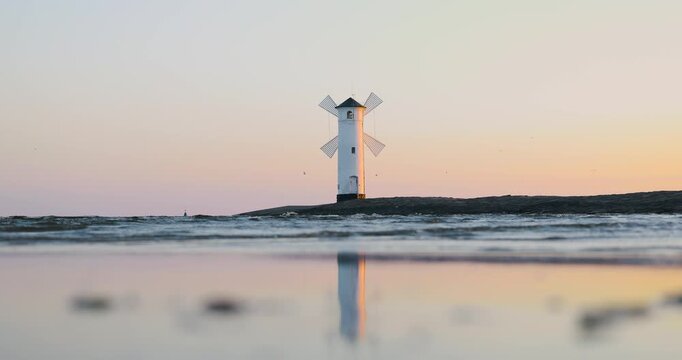Stawa Młyny in Świnoujście in Polen zur Morgend&auml;mmerung mit goldenem Morgenlicht auf der M&uuml;hle, ruhiger Ostsee und Spiegelung im stillen Wasser