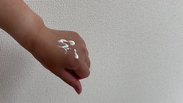 日焼け止めクリームを塗る手元