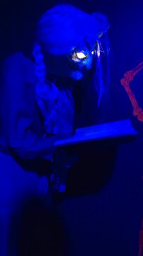An animatronic old witch casting a spell whose eyes glow in the dark at Halloween.
