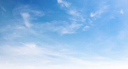 Fototapeta premium Clear blue sky with wispy clouds drifting gently