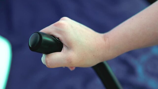 Close-up of a hand gripping and moving the handle of an exercise machine