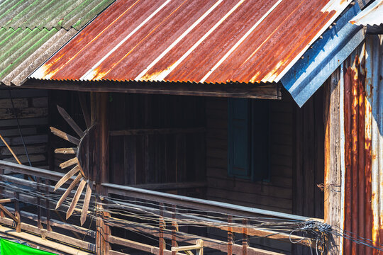 Old traditional wooden house balcony featuring unique sunburst wood carving decoration and designed to prevent people from climbing over balcony. Sunburst design by wood craft. Traditional lifestyle