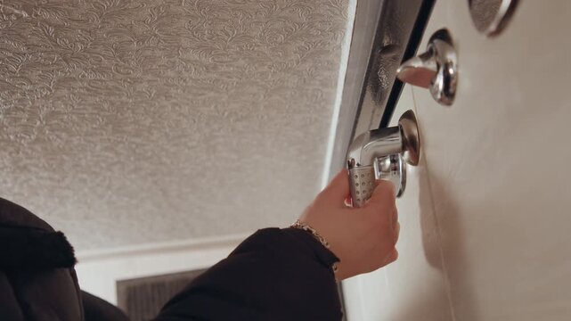 Turning key unlocks inviting cozy interior beyond. Closeup of key turning opens welcoming tiled room. Detailed shot of key inserted unlocks welcoming interior with tiled flooring and warm light