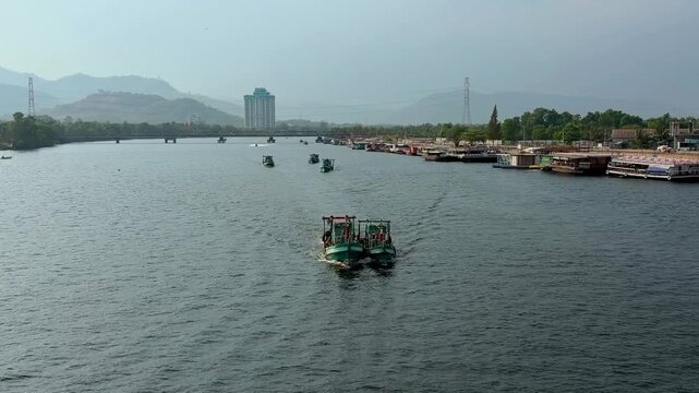 Traditional fishing boats navigating river in Kampot, Cambodia