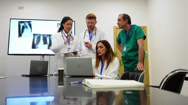 Diverse group of doctors and surgeons analyzing chest x ray scans during a hospital meeting. Medical professionals collaborating on a case