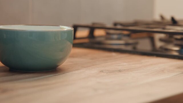 Egg near bowl. Egg situated next to ceramic bowl and dish. Egg located adjacent to glazed ceramic dish and nearby vessel. An egg positioned close to ceramic bowl and glazed dish next to it
