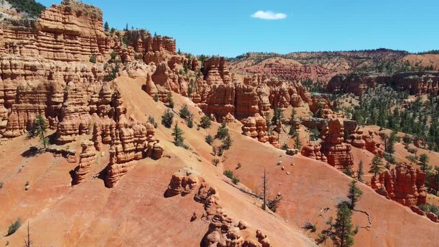 Cinematic drone footage flying over Dixie National Forest in Utah. Stunning aerial view of dramatic red rock spires, hoodoos, and geological formations similar to Bryce Canyon. 