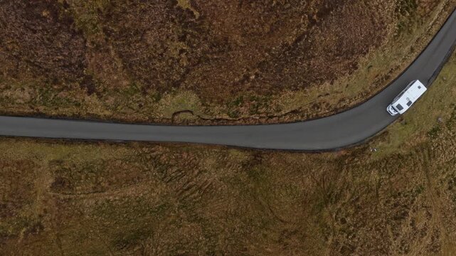 White camper van driving on winding quiraing road in scotland