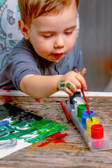 Curious young child exploring colors and creativity through painting. Preschool education, artistic development and learning through play concept. © zwiebackesser