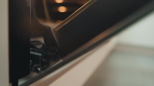 Close examination of hinge features. Careful assessment of oven hinge under gentle lighting conditions. Indepth review focusing on intricacies of oven door hinge mechanisms with warm illumination