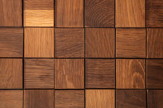 Different shades of wood blocks arranged in a square pattern on a flat surface for display or decoration in a workshop setting