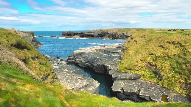 A wide shot landscape of rocky coastal cliffs and sea waves shown, ideal for tourism marketing campaigns, travel vlogs, and geological educational videos.