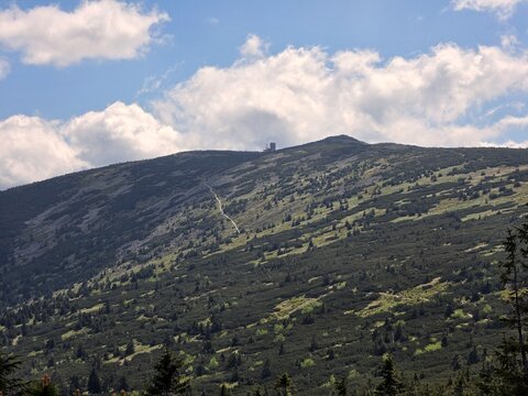 Mountain slope with hiking trail leading to distant peak in Karkonosze