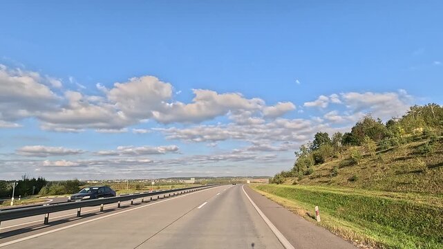 The car drives along the road on a summer day. Highways, roadside and road line markings.