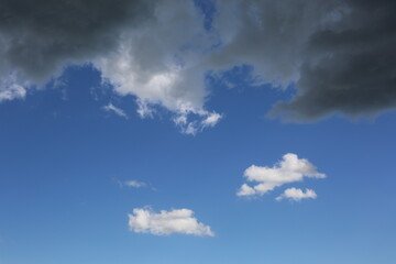 Obraz premium Blue sky with white and dark clouds