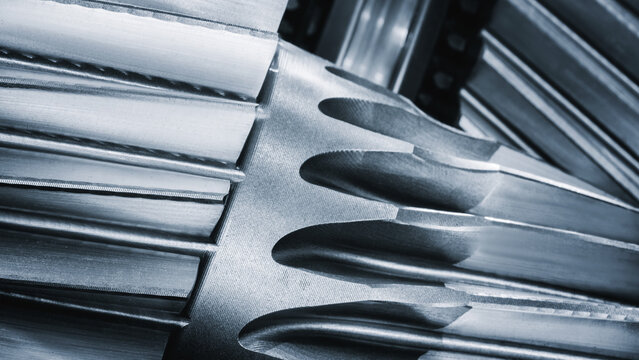 metal gears in black and white. Sharp teeth create precision engineering details. Shiny surfaces highlight craftsmanship of machining process. Industrial equipment component, industrial background.