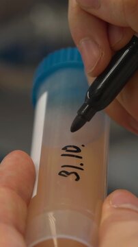 Detailed Writing Of Dates And Identifiers On Laboratory Sample Containers For Traceability . Stock clip