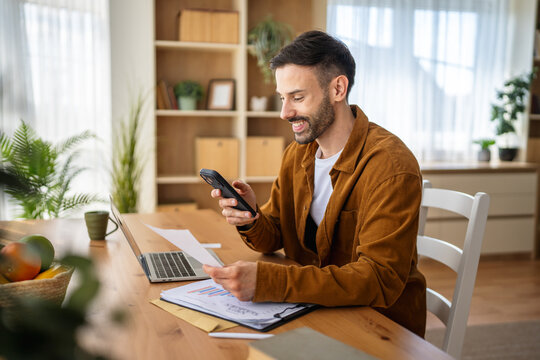 Man scanning documents with smart phone working from home