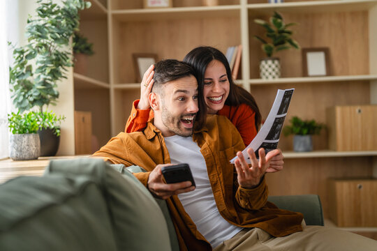 Happy couple looking at sonogram image expecting baby