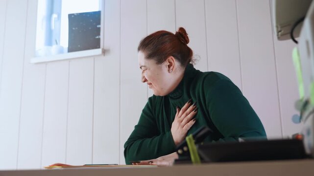 Woman clutching chest at home office while writing, desk scene with notebook and pen, visible tension and shallow breathing, midway through task then sudden pain, deadline stress and urgent health