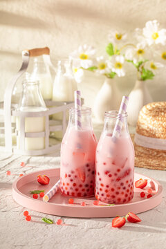 Cold and homemade strawberry bubble tea with berries and milk.