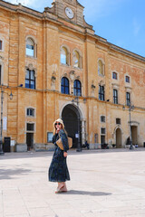 Fototapeta premium Woman walking through a picturesque European destination with historic buildings, leisure travel and vacation lifestyle concept
