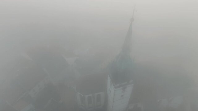 Aerial View of Historic Church Spire and Red Rooftops in Foggy Cesky Krumlov Old Town, Czech Republic