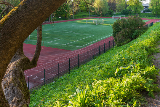 Local football stadium surrounded by greenery at sunset in urban park