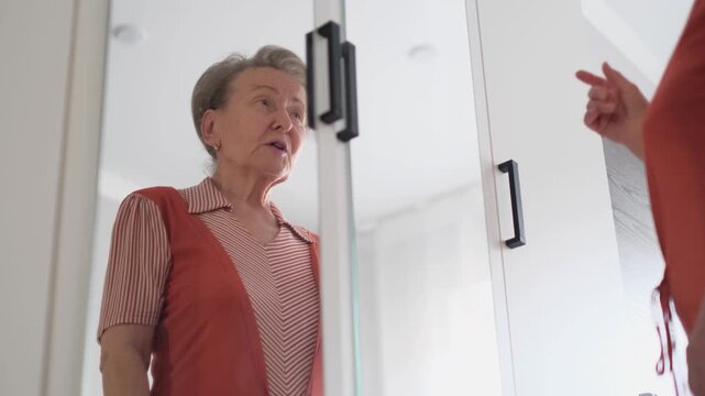 A contented old woman talks to herself while looking in the mirror