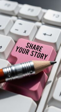 Close-up of a pink keyboard key with the words SHARE YOUR STORY and a pencil tip.