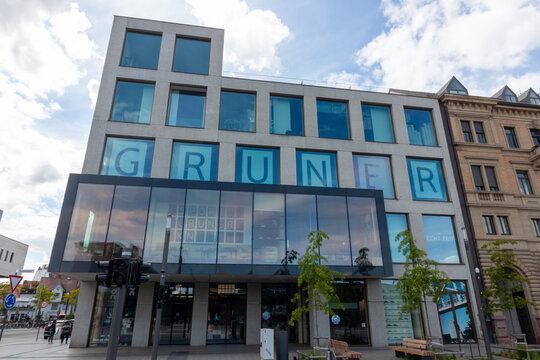 The contemporary facade of the Sport Gruner building, featuring a minimalist grid design with large square windows and a prominent glass-enclosed second floor