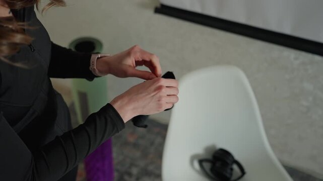 Woman organizing equipment. Woman carefully arranges her training equipment in methodical manner. Woman prepares and organizes her workout tools with precision and calmness before exercise