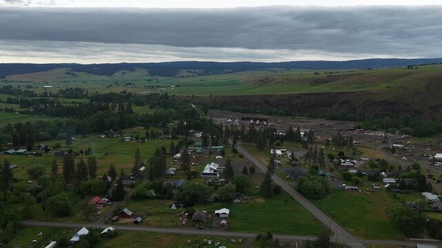 Aerial of Wallowa small rural town in east Oregon in spring in mountains with stormy sky