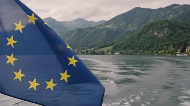 Eu flag waving on a boat with beautiful mountain lake in the background, european travel and tourism concept