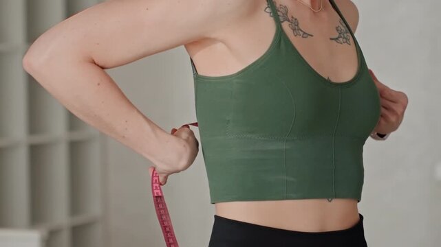 Tracking female torso dimensions accurately. Assessing female chest and torso size with pink tape measure. Detailed process of measuring female torso circumference around chest using pink tape
