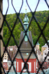 Obraz premium View from a castle window through a forged iron grate to an ancient tower.