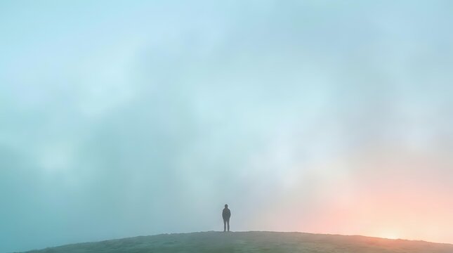 Silhouette of solitary figure standing on hilltop at sunrise or sunset with misty atmospheric landscape, conveying contemplation, solitude, and new beginnings for editorial and motivational use.