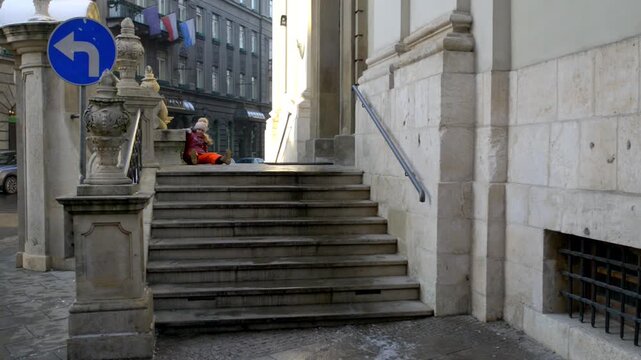 Little beautiful girl walks near Church of the Transfiguration (Rector's church) at 2 Pijarska Street in Krakow, Poland.