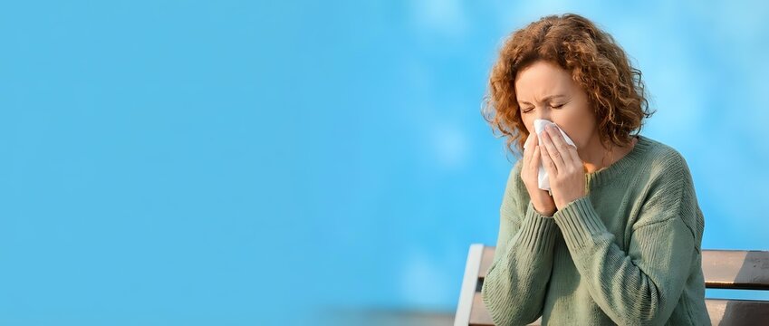 Woman Blowing Nose with Tissue During Cold or Flu Season, Allergy and Illness Concept