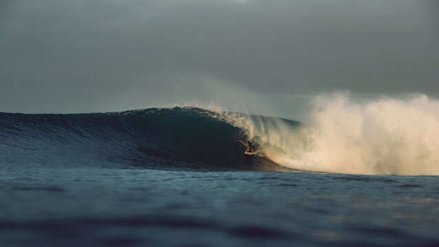 surfer large tubular wave sunrise atlantic ocean