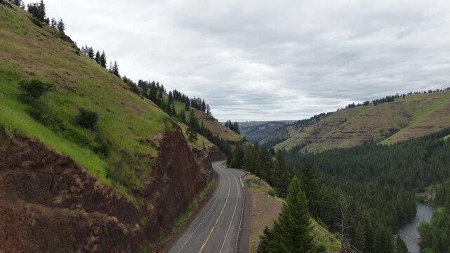 Aerial of highway 82 near Minam Oregon in spring time along river and hillsides