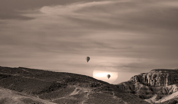 Silhouette of hot air billon over mountain in sunrise