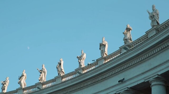  A panning shot of the impressive St. Peter's Square Colonnade in Vatican City, showing the giant columns and tourists strolling through the majestic covered architectural passage.

