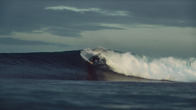 surfer large tubular wave sunrise atlantic ocean